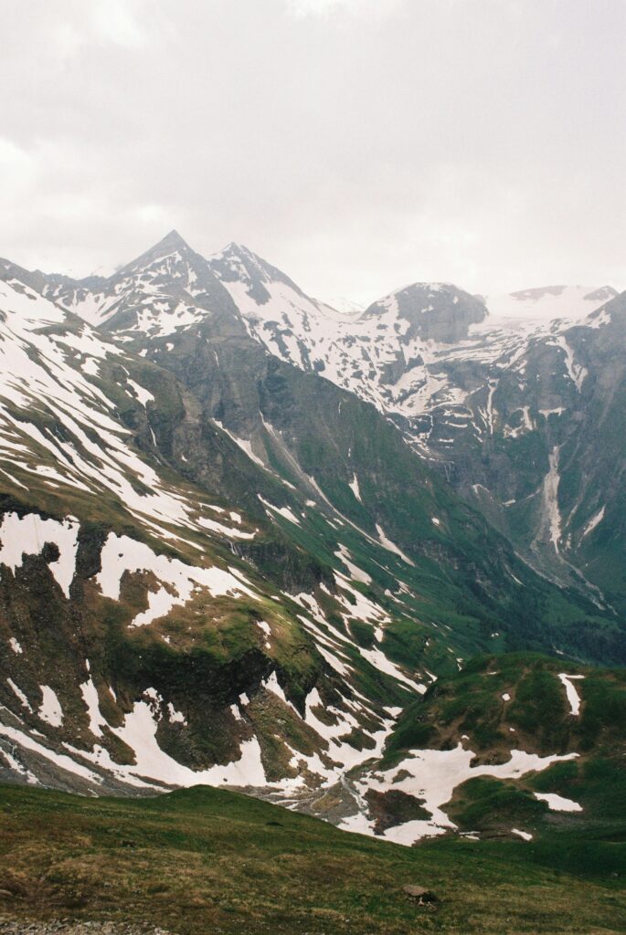 A breathtaking view of snow-capped mountains in the Austrian Alps during summer.